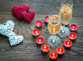 Two glasses of champagne inside of burning candles photo