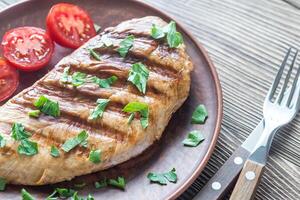 Grilled turkey breast with parsley and tomatoes photo