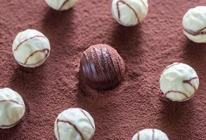 Chocolate candies on cocoa background photo