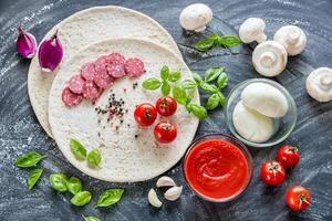 Pizza ingredients on the dark wooden background photo