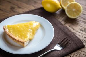 Slice of lemon tart on the plate photo