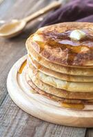 Stack of pancakes with butter and maple syrup photo