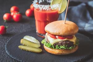 Hamburger with a glass of tomato juice photo