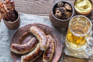 Grilled sausages with fried bacon rashers and mushrooms photo