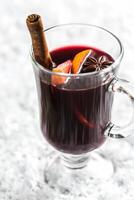 Glass of mulled wine in snow photo