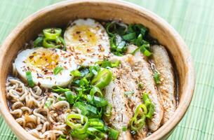 Bowl of chicken ramen soup on the wooden table photo