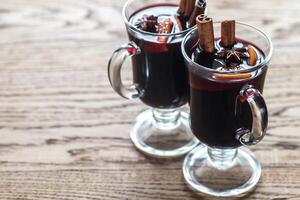 Two glasses of mulled wine on the wooden background photo