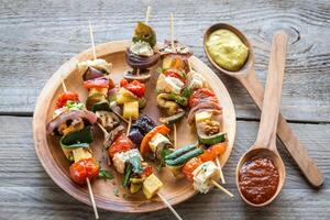 brochetas de verduras a la parrilla en el plato foto