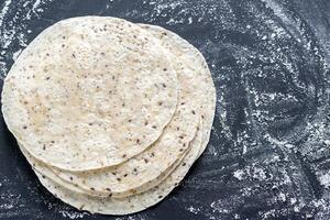 Stack of tortillas on a black surface photo