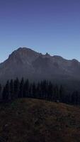 A view of a mountain range with trees and mountains in the background video