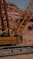 A large yellow crane sitting on top of a rocky hillside video