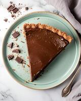 AI generated Vegan chocolate pie on a light green plate, placed on a marble table, around it there are pieces of chocolate photo