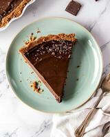 AI generated Vegan chocolate pie on a light green plate, placed on a marble table, around it there are pieces of chocolate photo