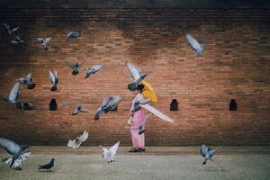 Asian girl and Flying pigeons near Tha Phae gate at Old city in Chiang Mai Thailand photo