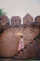 niña en frente de histórico eso fae portón a antiguo ciudad en chiang mai Tailandia foto