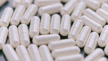 looped spinning full frame macro medical background of white drug pill capsules video