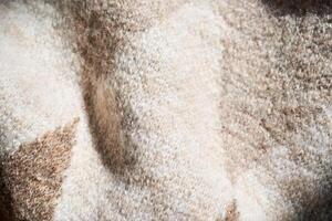 The texture of a warm sweater with a beige pattern. photo