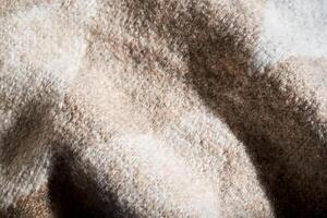 The texture of a warm sweater with a beige pattern. photo
