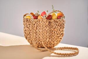 Easter colored eggs in a wicker bag. Easter composition. photo