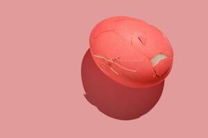 Cracked pink Easter egg on a pink background. photo