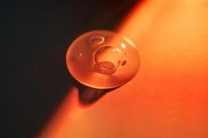 A drop of sunscreen body gel in the orange sunset light. photo