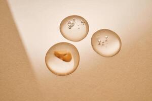 A drop of transparent cosmetic gel on a beige background. photo