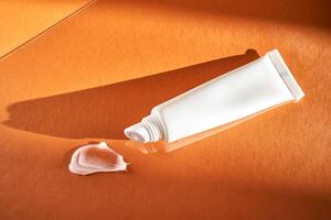 Hygienic moisturizing lip balm in a tube on a orange background. photo