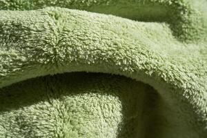 The texture of soft and delicate plush fabric in green color. photo