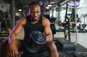 sano africano hombre trabajando fuera con pesas en gimnasio foto