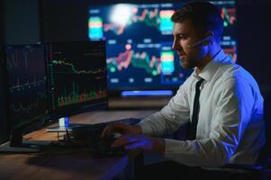 financiero analistas y día comerciantes trabajando en un ordenadores con multimonitor foto