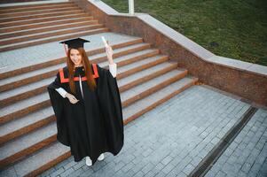 graduación estudiante en pie con diploma foto