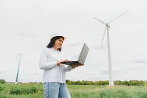 Environmental engineer with a laptop at wind farm photo