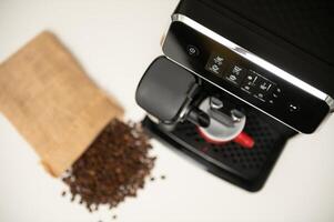 Modern espresso coffee machine with a cup in interior of kitchen closeup photo