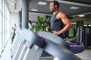 Man running on treadmill in gym photo