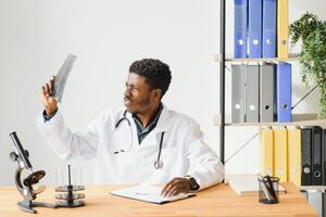 simpático africano americano médico en moderno oficina. foto