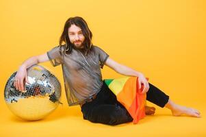 Gay man hold rainbow striped flag isolated on colored background studio portrait. People lifestyle fashion lgbtq concept photo