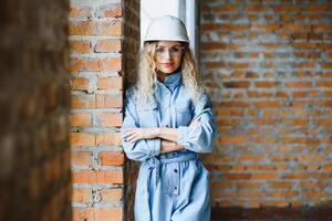 Warehouse woman worker. Woman builder in hardhat. Girl engineer or architect. Home renovation. Quality inspector. Construction job occupation. Construction worker. Lady at construction site. photo