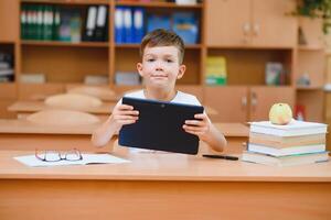 school boy using tablet compute in classroom photo