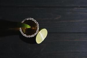 Mexican Gold Tequila with lime and salt on black background with copyspace. photo