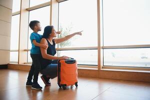 mujer y su niño paso mediante el aeropuerto terminal foto