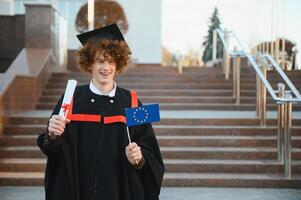 hermoso graduado en graduación resplandor con diploma. foto