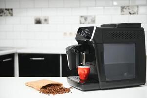blurred background of kitchen and coffee machine with red cup and space for you photo