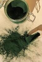 orgánico azul verde algas espirulina polvo comida en vaso tarro con de madera cuchara. salud beneficios de espirulina clorella. dietético suplemento superalimento concepto foto