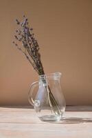 lavanda flores en vaso platos. seco herbario flores en beige antecedentes. mínimo todavía vida eco concepto. ideal espacio para mostrando productos cosméticos con lavanda extracto. Copiar espacio foto