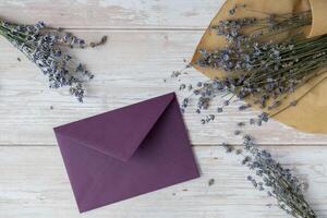 Empty violet envelope paper template mock up. Copy space for your text. Lavender flower. Greeting or invitation card blank with envelope. Top view, flat lay photo