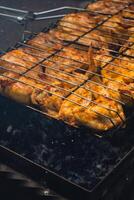 BBQ picnic time Roasted chicken legs and wings on grill. Grilling meat on outdoor grill grid tasty barbeque chicken steak with smoke flames juicy meat in the backyard in summer photo