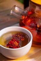 Marigold flower healthy tea in glass mug with tea pot on garden table. Herbal medicine Delicious tisane tea with fresh yellow blossom dandelion flowers tea cup. Green clearing infusion Wildflowers Eco friendly sustainable eating photo