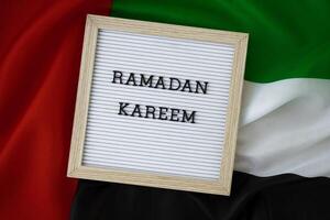Message RAMADAN KAREEM - happy holidays waving UAE flag on background concept. Greeting card advertisement. Commemoration Day Muslim Blessed holy month public holiday photo