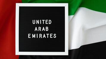 mensaje unido árabe emiratos en antecedentes ondulación bandera de eau nacional día festivo, independencia conmemoración día musulmán, Felicidades. árabe vacaciones. anuncio de dubai celebracion foto