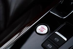 Start engine stop button Interior of modern luxury car. Details of automatic transmission gear shift, multimedia control system, car control panel, Air Vent Red emergency button and dashboard inside. Prestige sport automobile. Selective focus photo